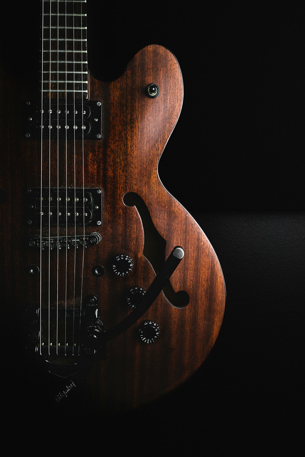 a close up of a guitar on a black background