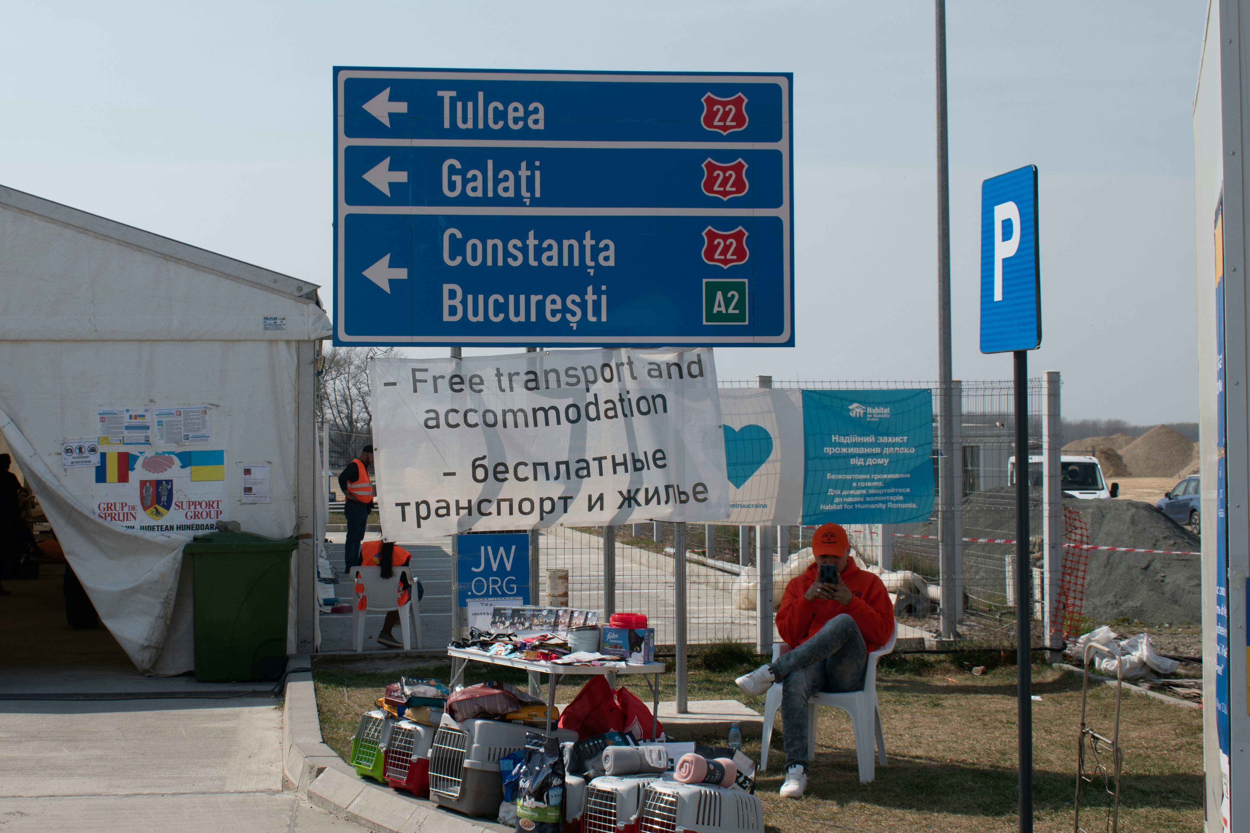 Eine Frau sitzt auf einer Bank neben einem Straßenschild