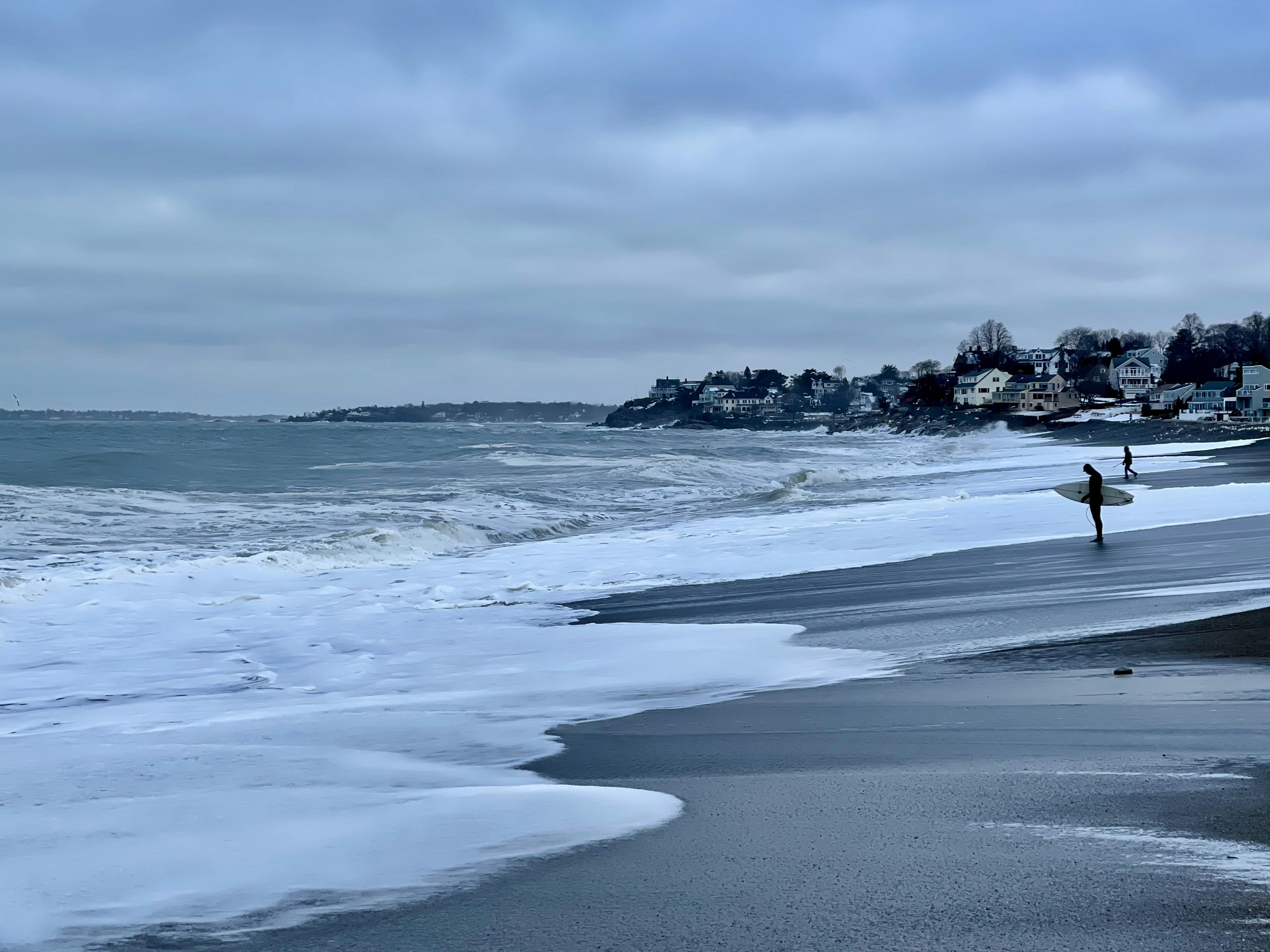 a person holding a surfboard on a beach