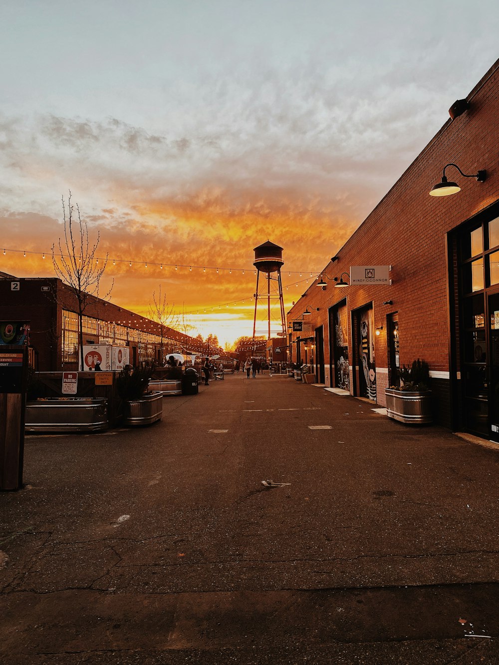 an empty street with a water tower in the distance