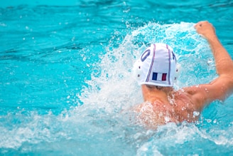 Youth water polo players practicing teamwork during an intense training session at a sunny outdoor pool.