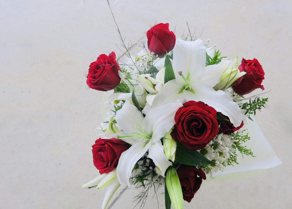 a bouquet of red roses and white lilies