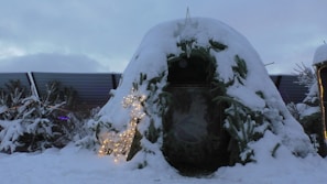 A whimsical ice igloo illuminated from within on a snowy background.