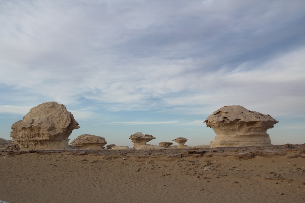 a group of rocks sitting on top of a sandy beach