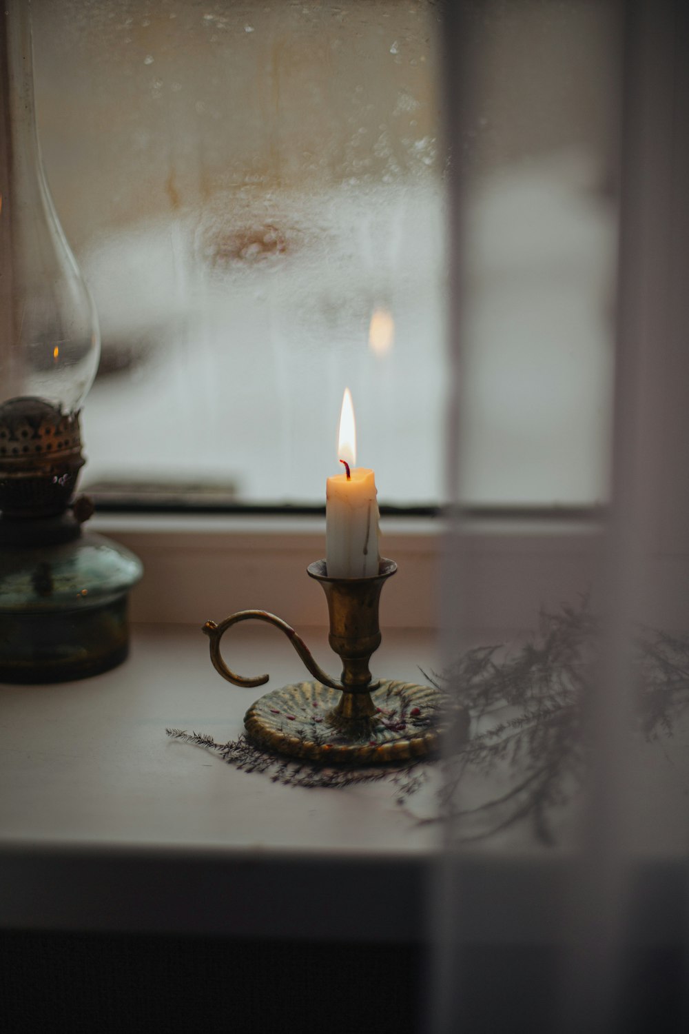 a candle sitting on top of a table next to a window