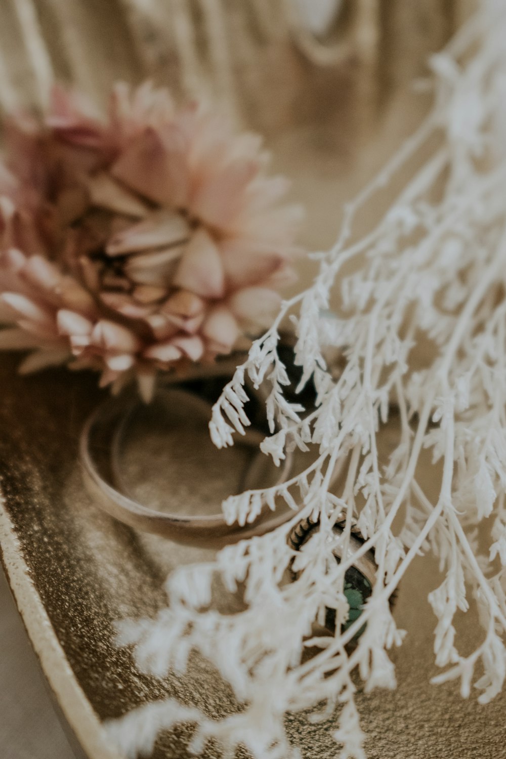 a close up of a flower and a ring on a tray