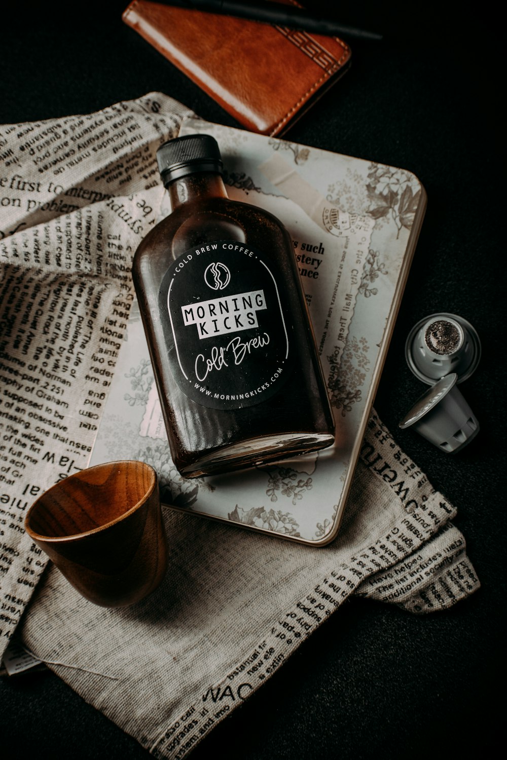 a bottle of booze sitting on top of a newspaper