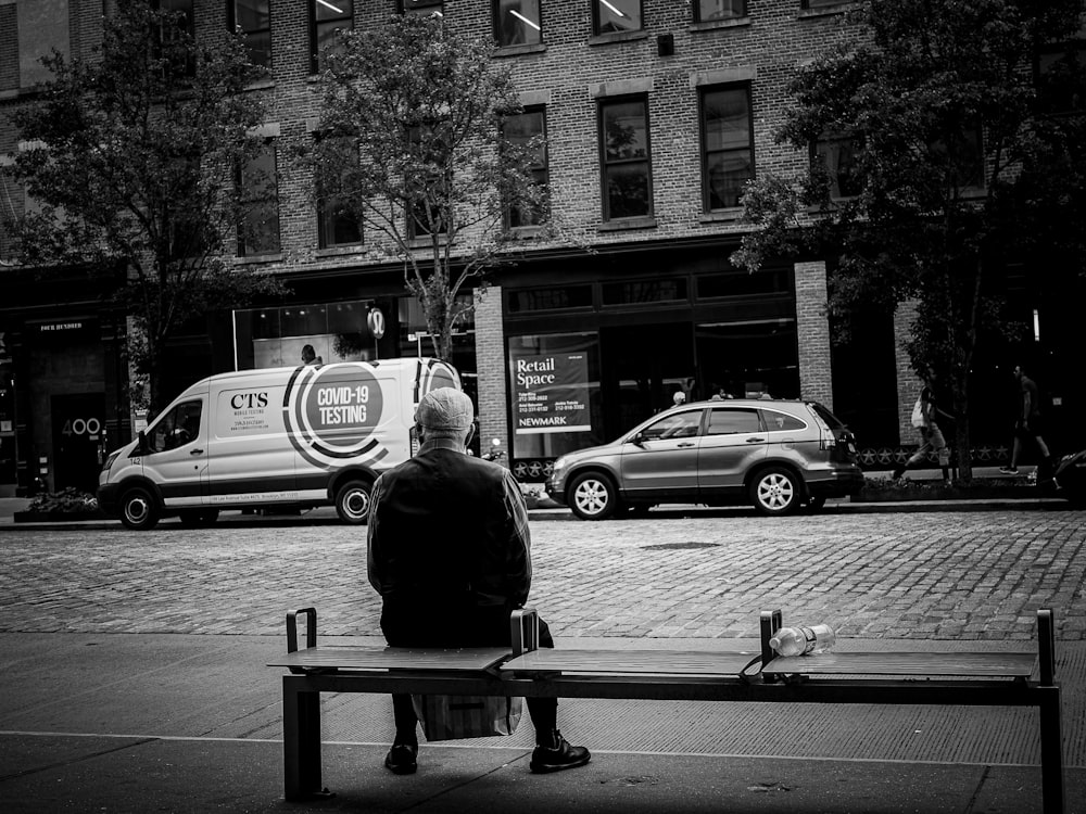 ビルの前のベンチに座る男