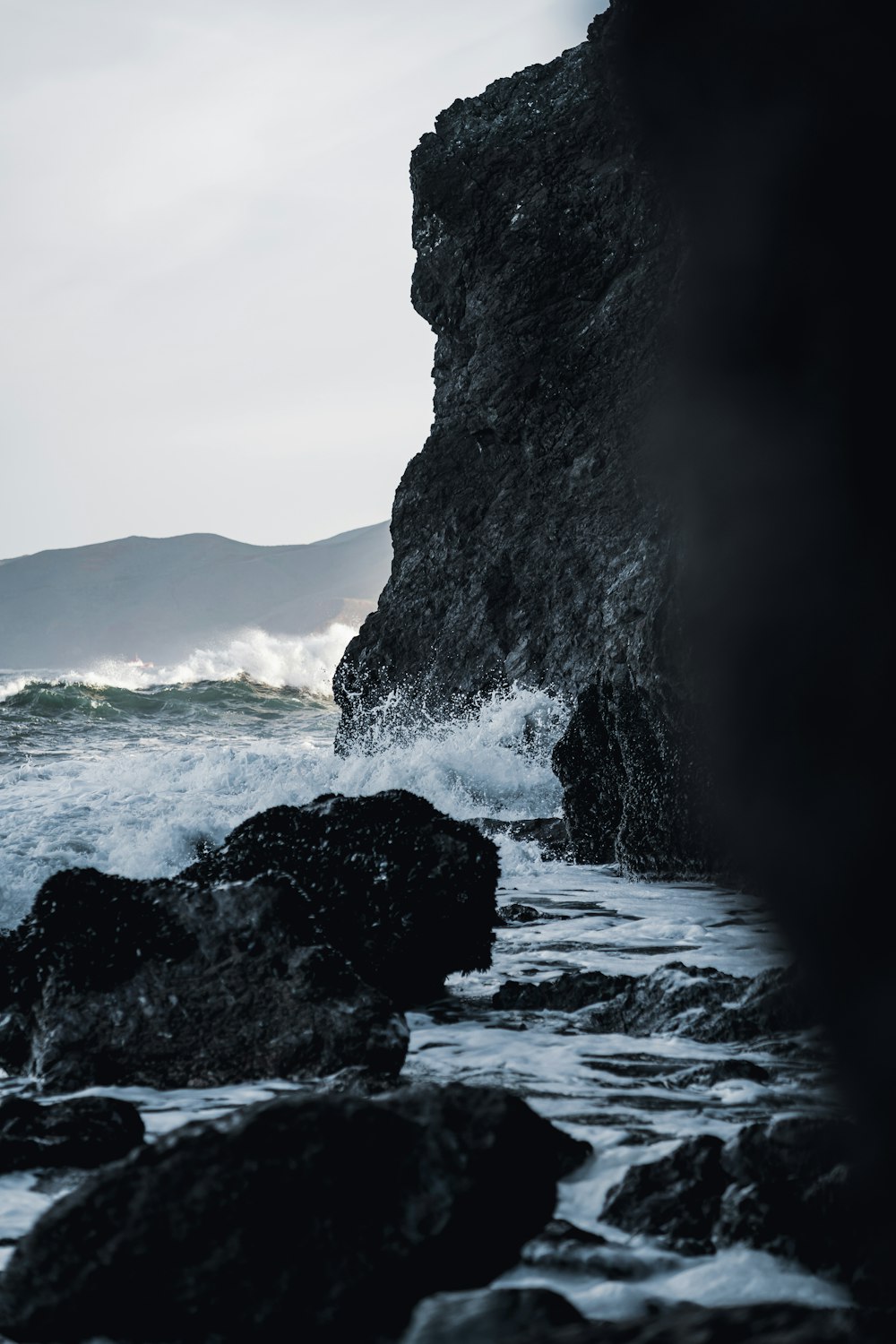 a large waterfall over a rocky beach