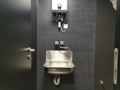 a bathroom stall with a sink and soap dispenser