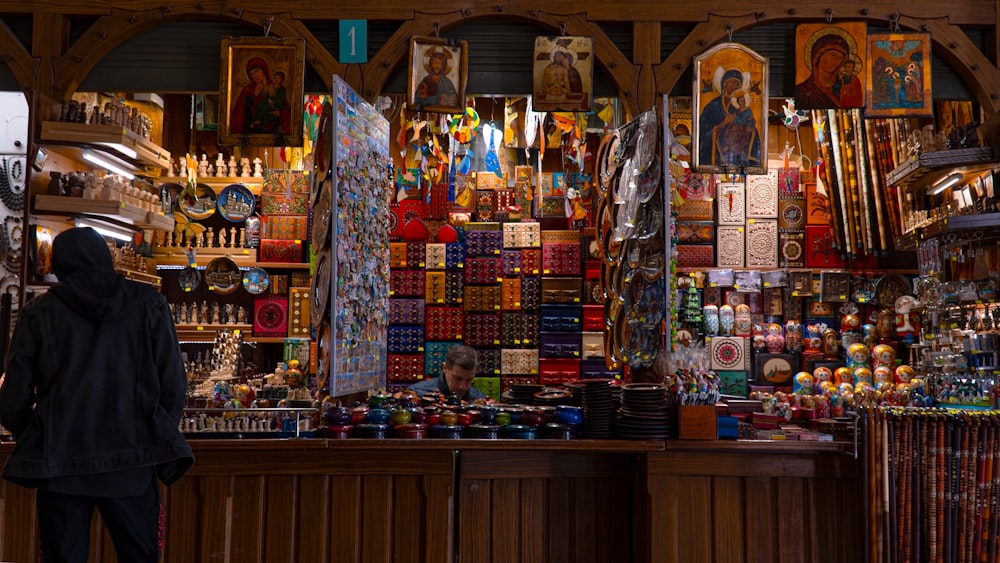 a person standing in front of a store filled with items