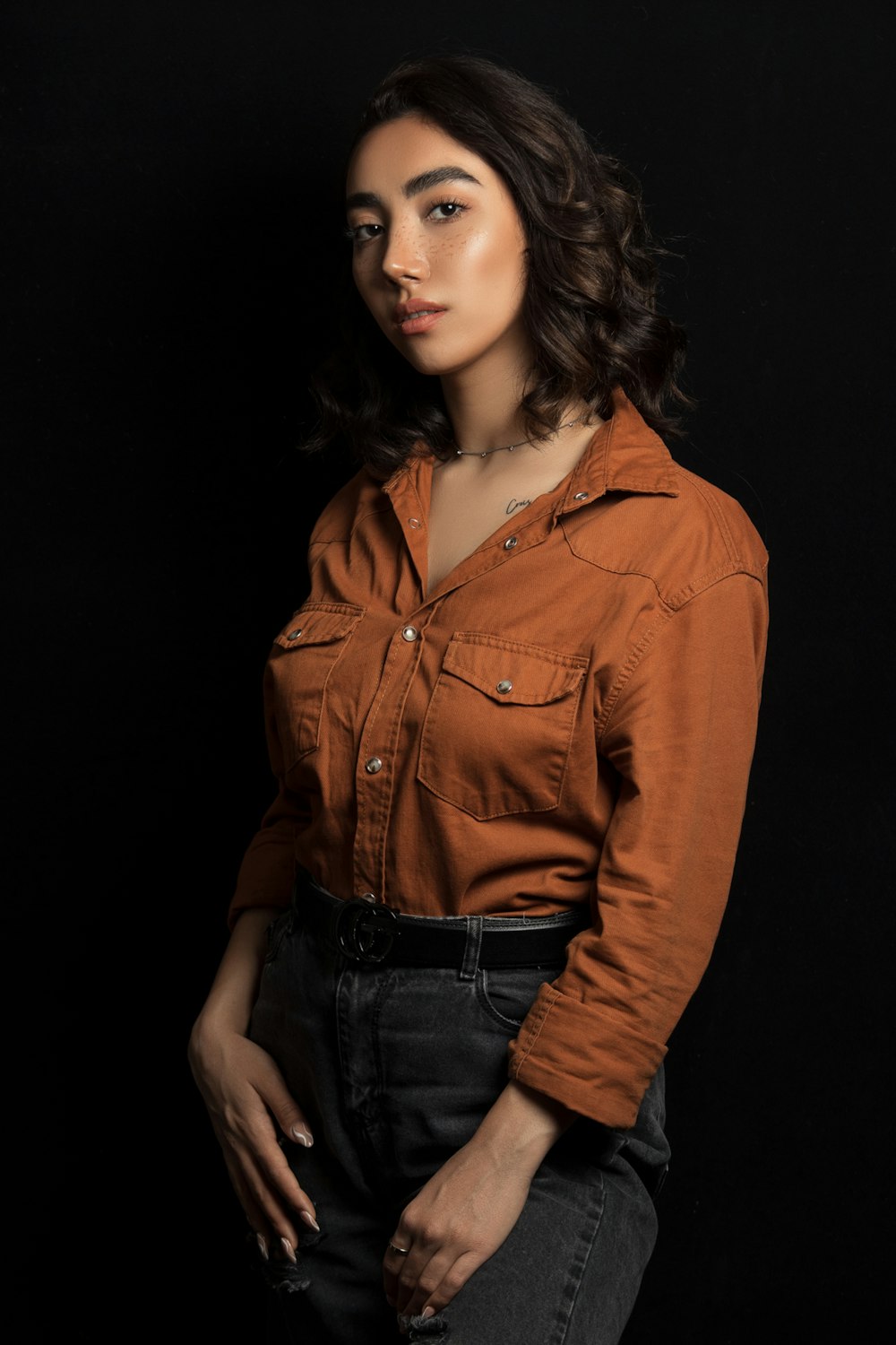 a woman in a brown shirt posing for a picture