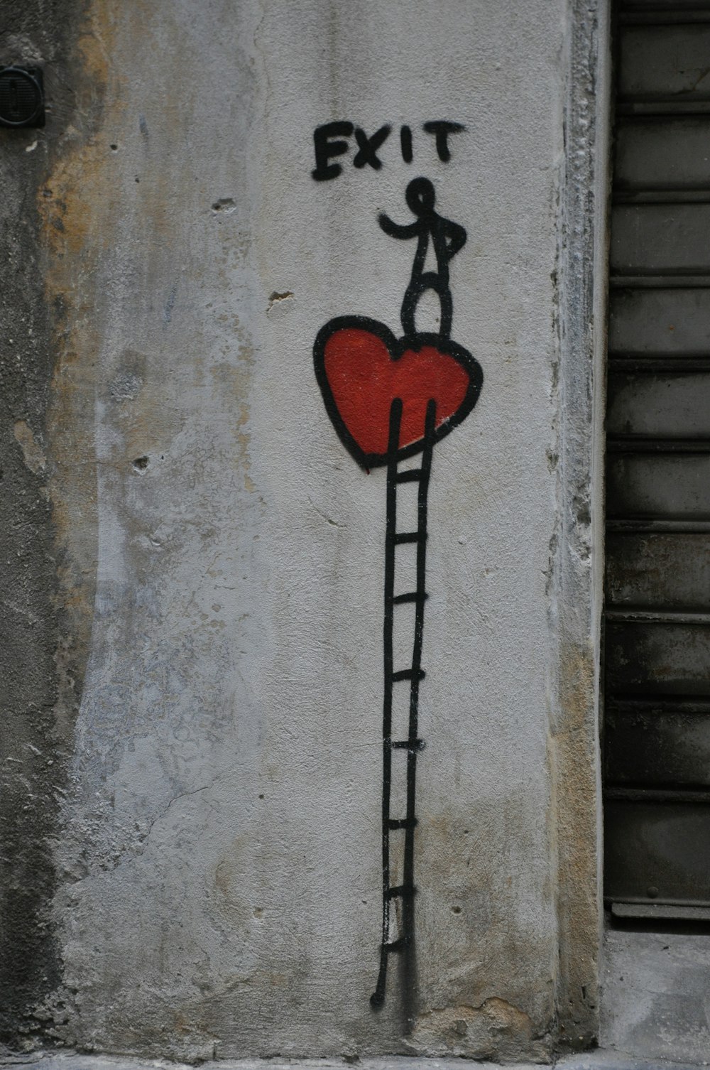 a graffiti of a man climbing up a ladder with a heart on it