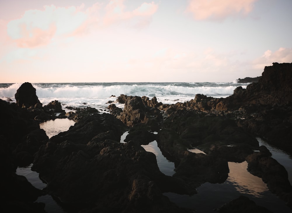 a rocky beach with waves crashing in to shore