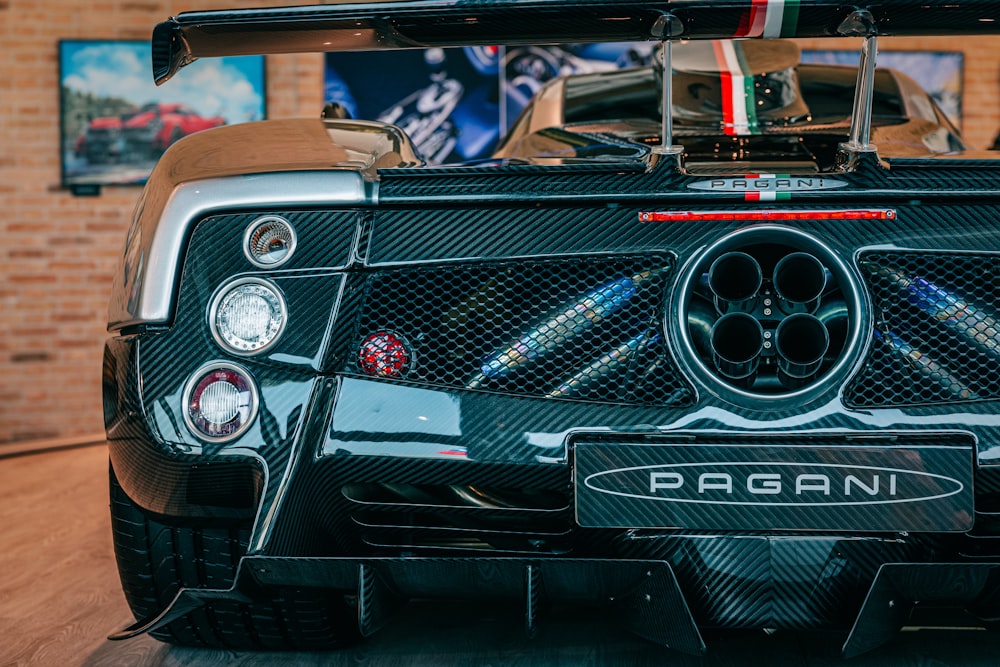 a black sports car parked in front of a brick building