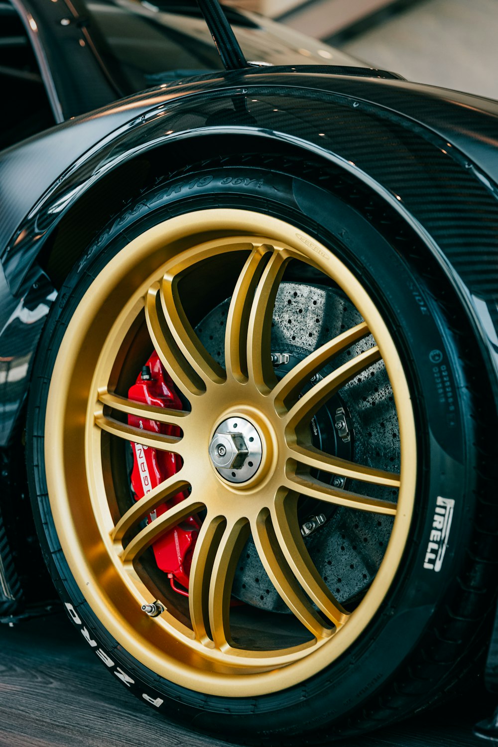 a black sports car with gold rims parked in a garage