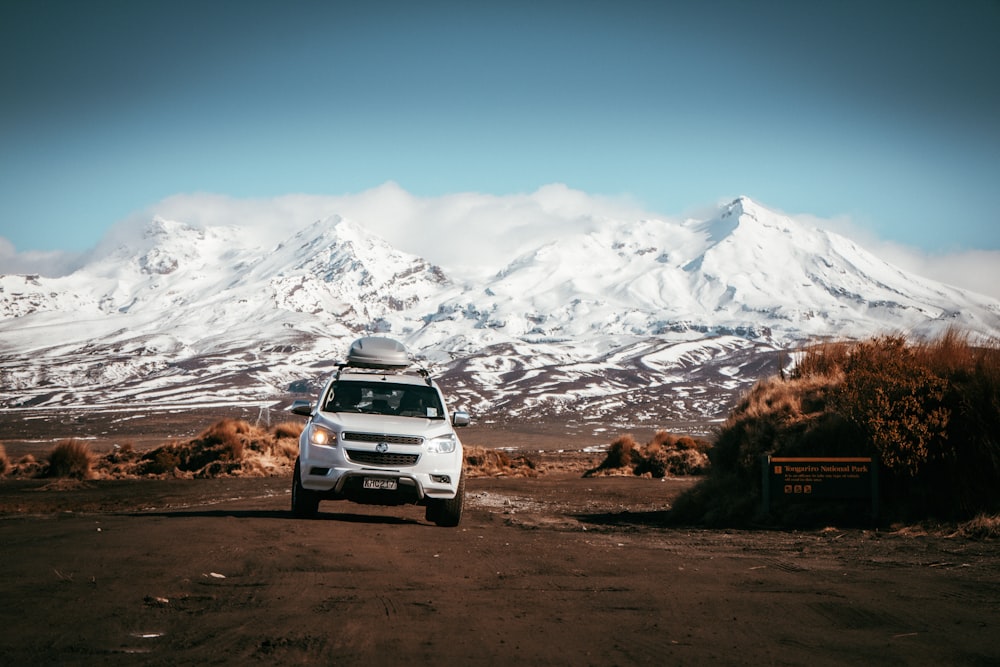 a white van parked in front of a snow covered mountain