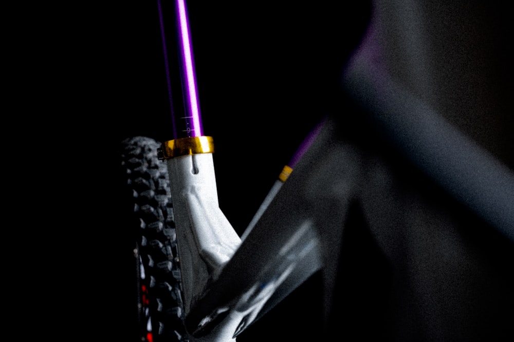 eine Nahaufnahme eines Fahrrads mit einem lila Licht darauf