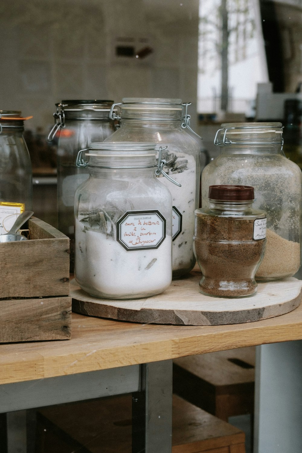 a wooden table topped with glass jars filled with food