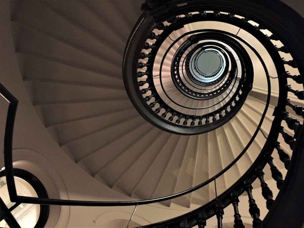 eine Wendeltreppe in einem Gebäude mit schwarzen Geländern