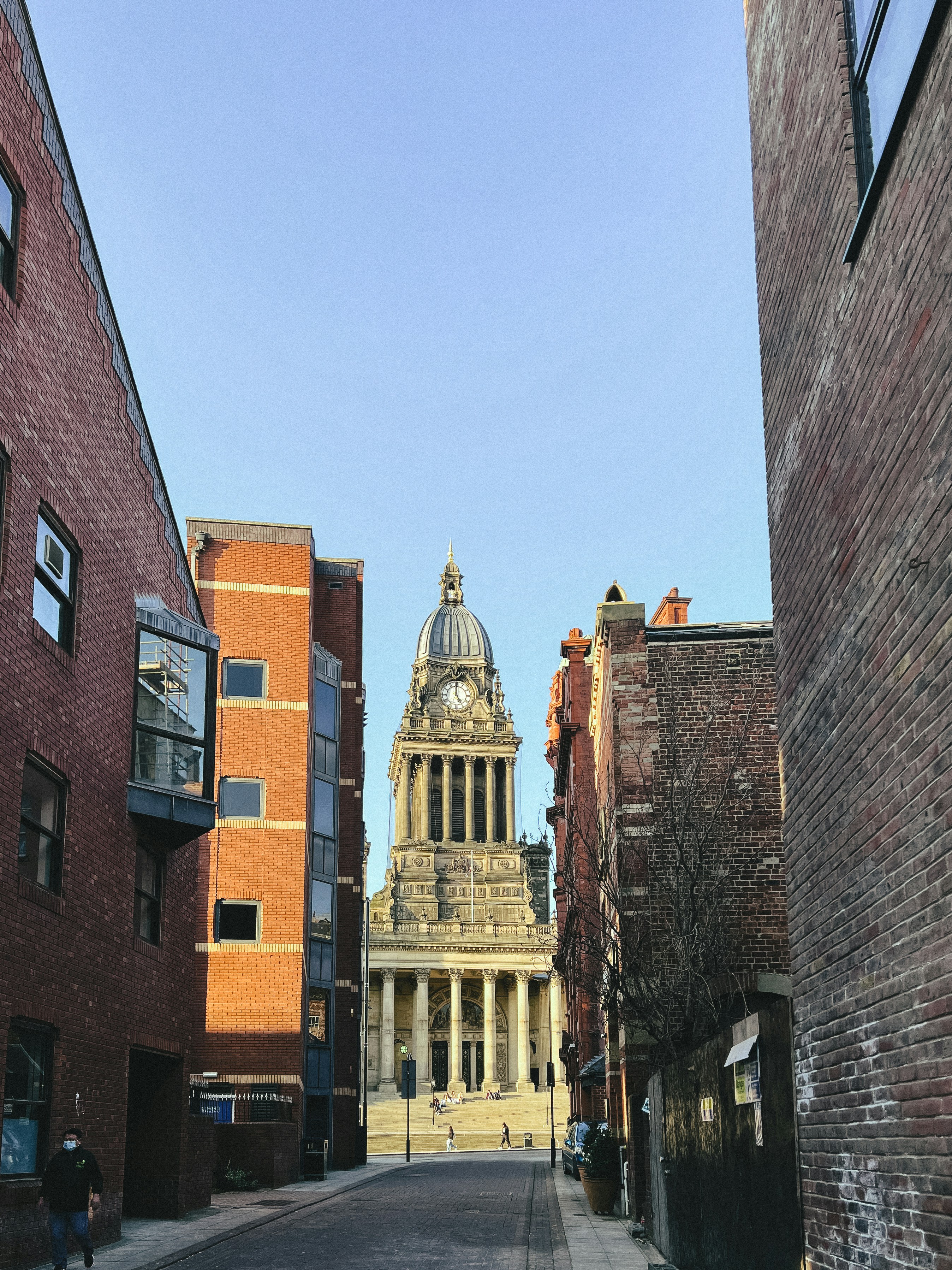 A city street with buildings and a clock tower photo – Free Person ...