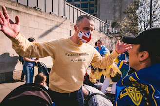 A close-up of a vibrant yellow t-shirt with a bold red Lithuanian slogan printed on the chest.