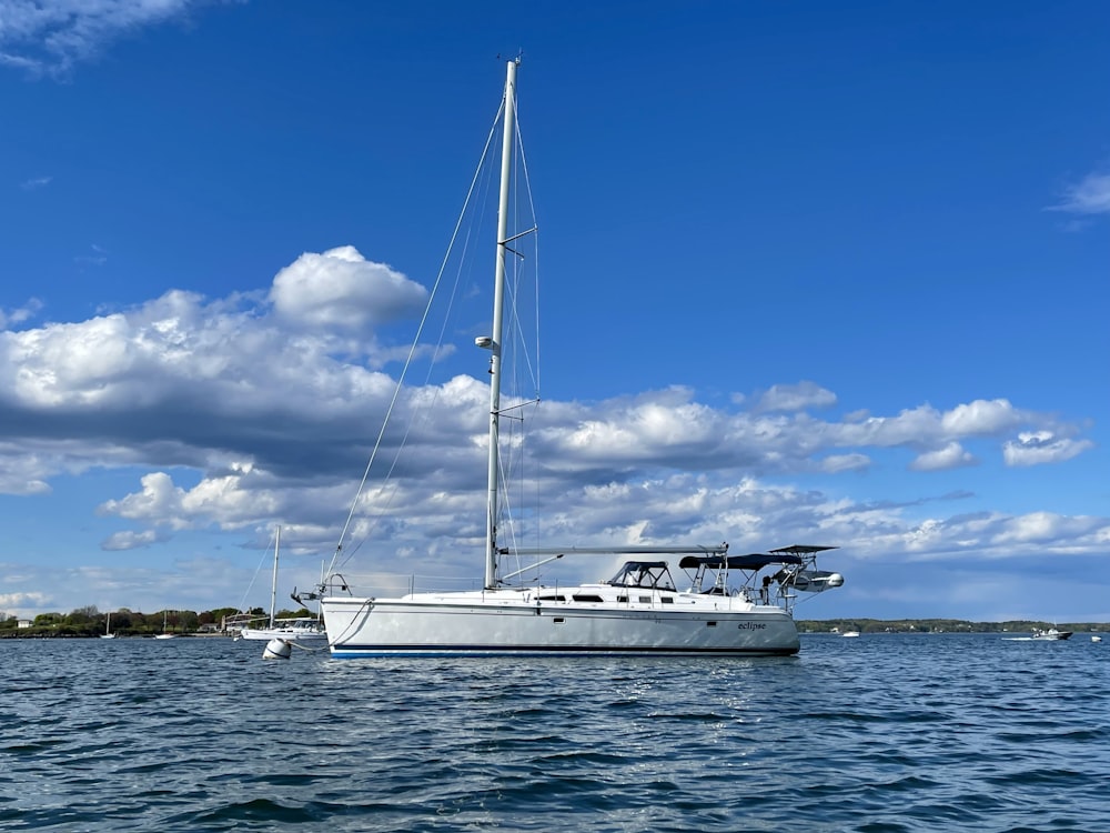 a white sailboat floating on top of a body of water