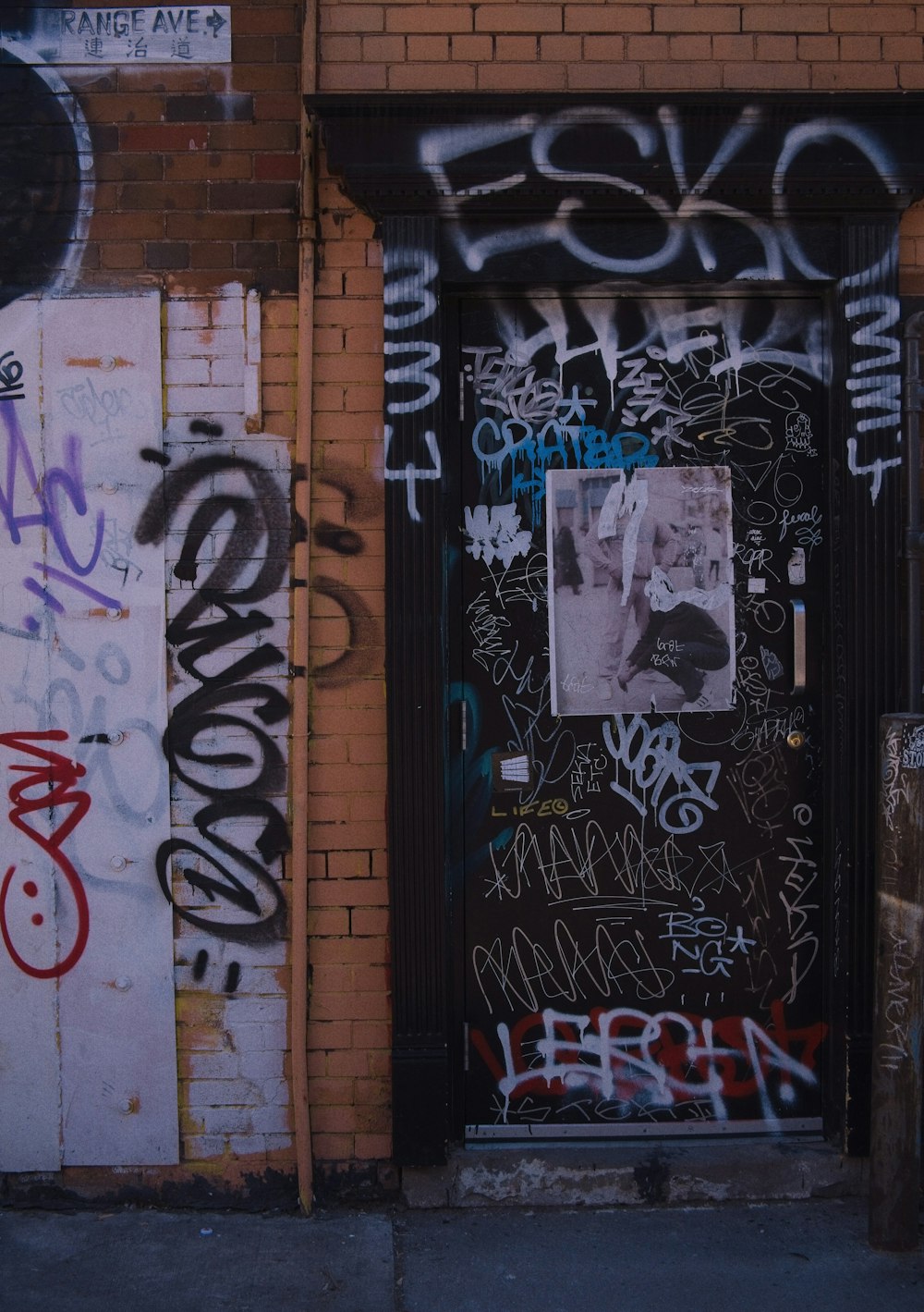 a door covered in graffiti next to a brick building