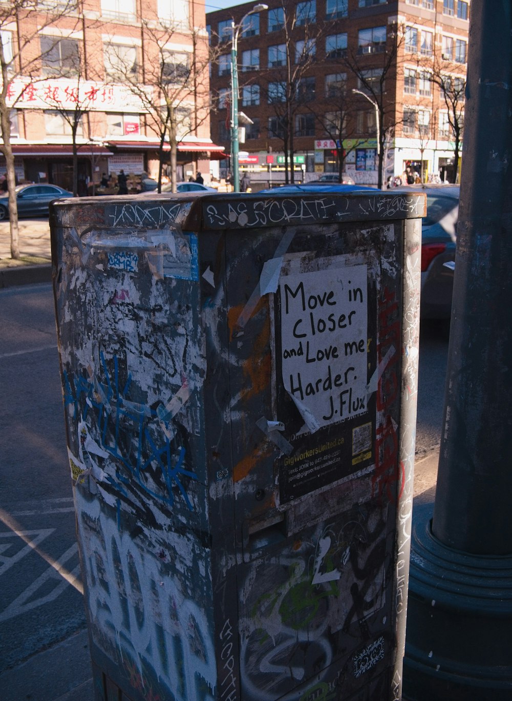 a trash can covered in graffiti on a city street