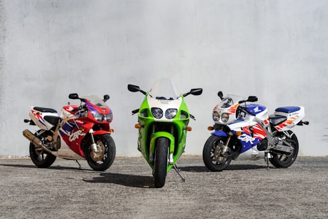 three motorcycles parked next to each other in a parking lot