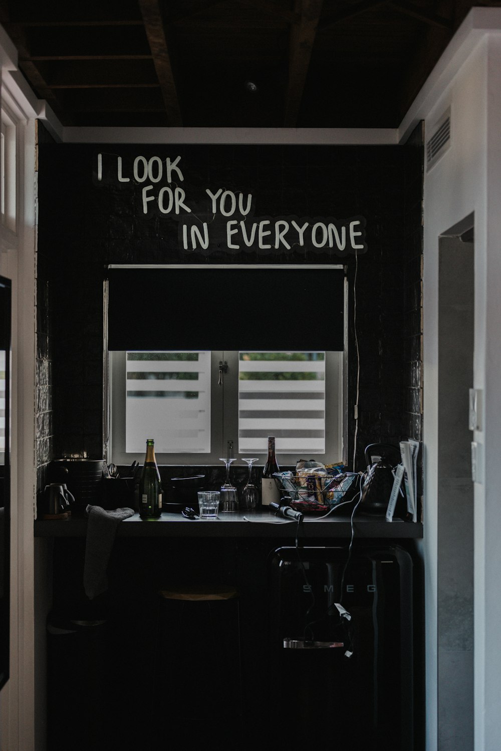 a kitchen with a black counter top and a sign that says i look for you