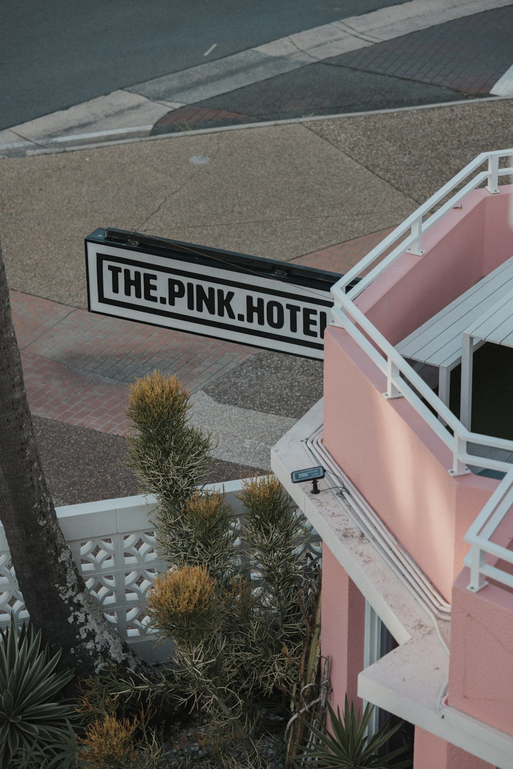 a pink hotel with a palm tree next to it