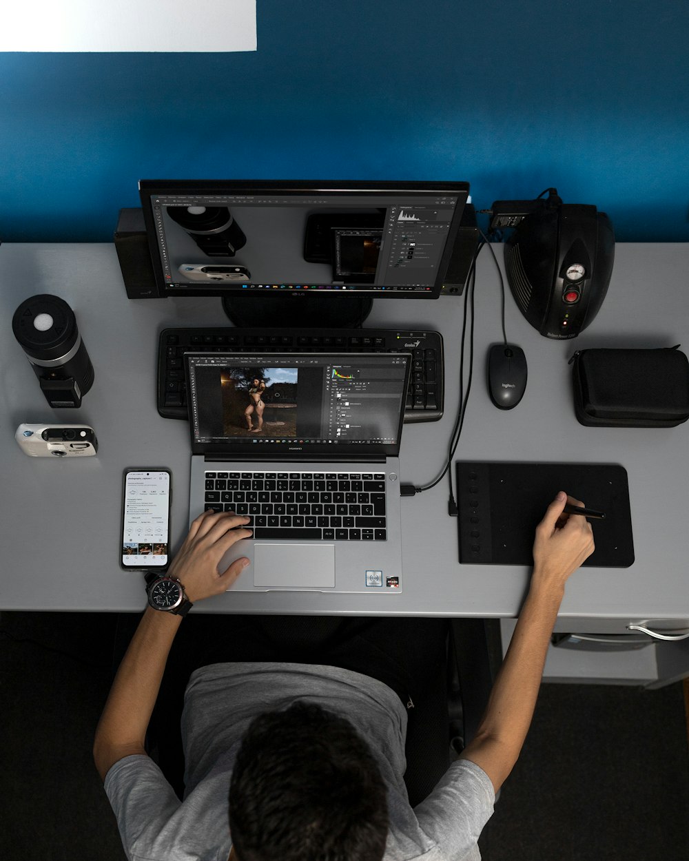 a man sitting at a desk with a laptop and a cell phone