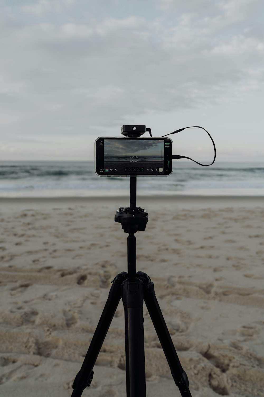 a tripod with a cell phone attached to it