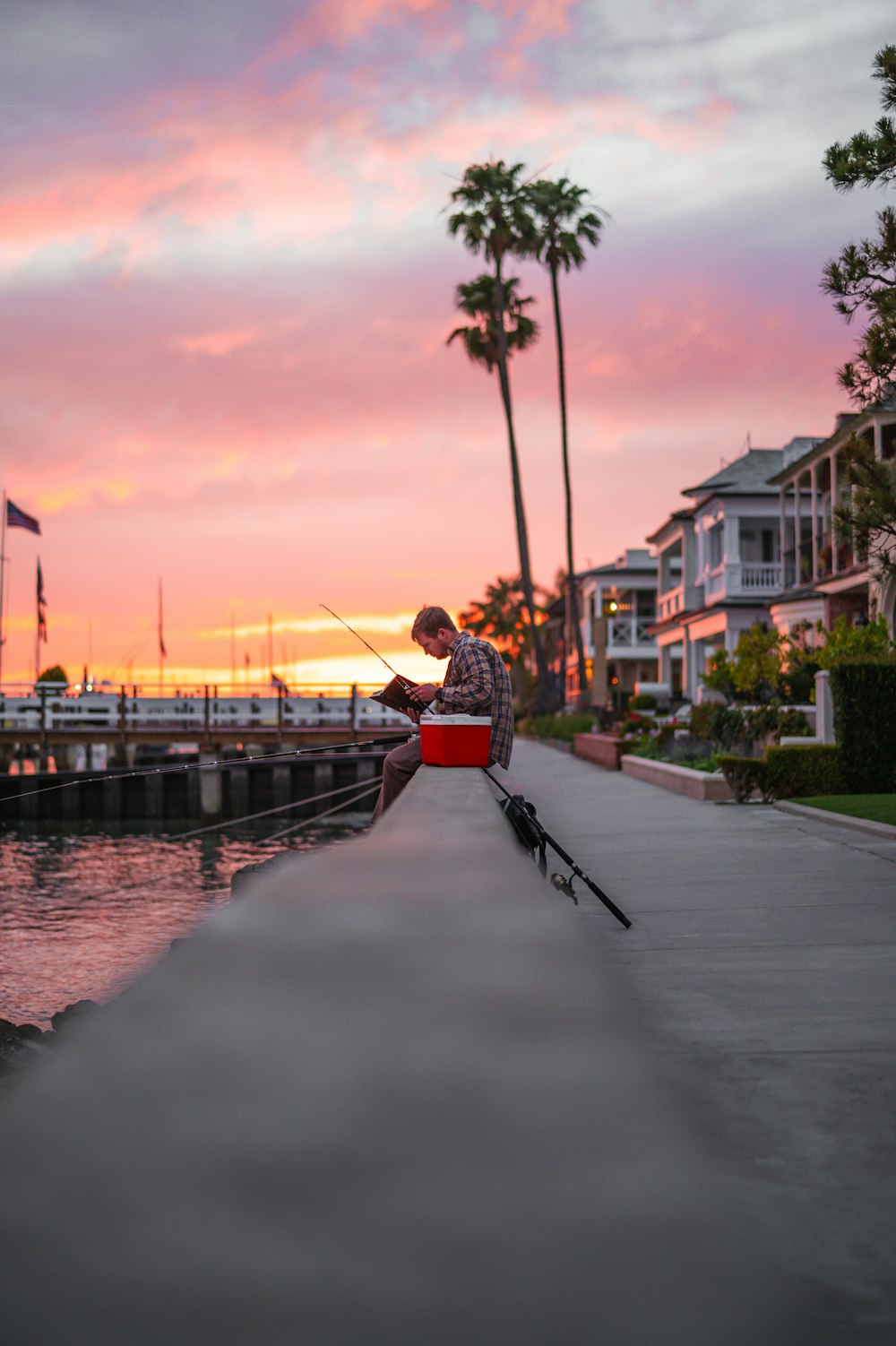 a man fishing from a dock at sunset