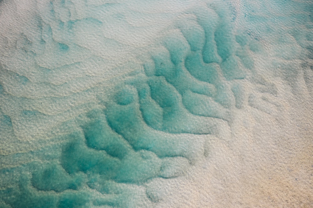 a sandy beach with blue water and white sand