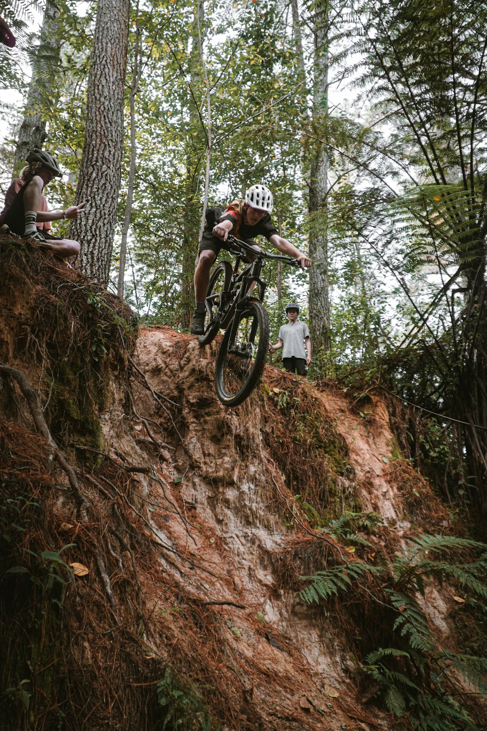 a man riding a bike down a dirt hill