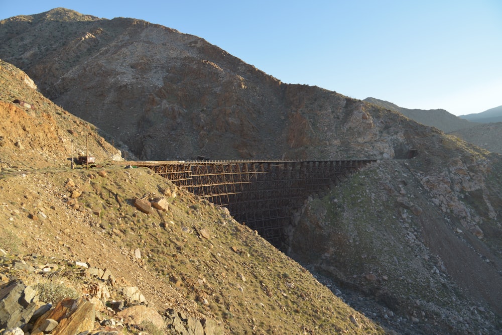 a train traveling over a bridge on top of a mountain