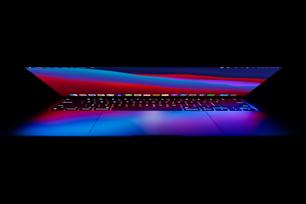 a laptop computer is lit up in the dark
