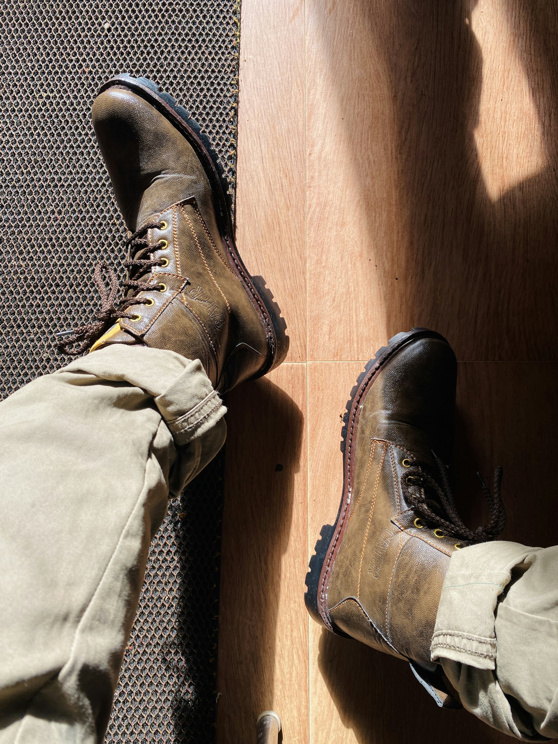 a pair of brown boots sitting on top of a wooden floor