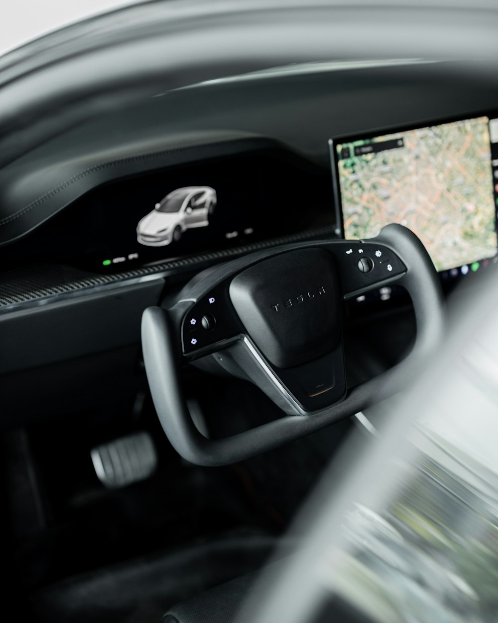 a car dashboard with a monitor and a car steering wheel