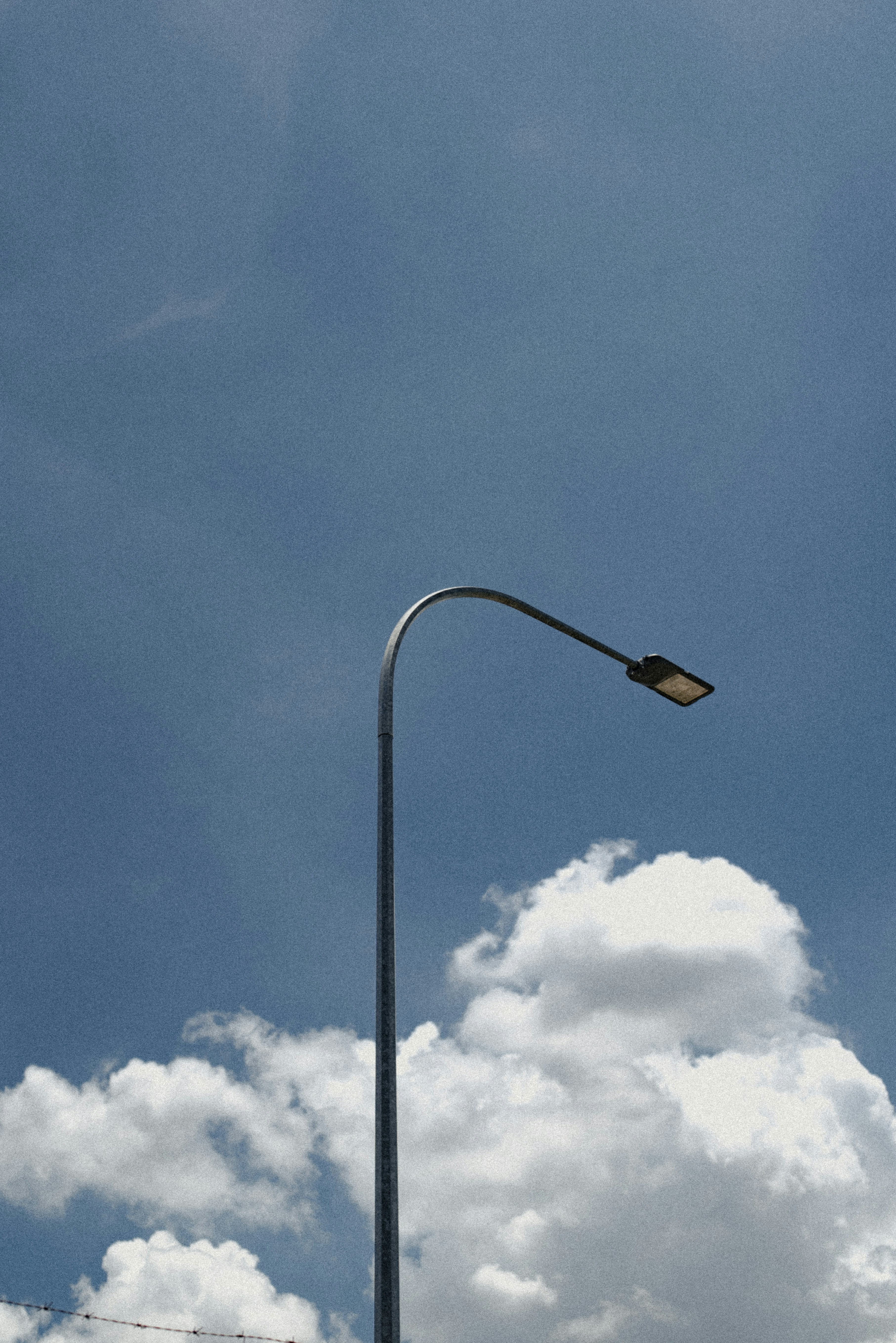 eine Straßenlaterne mit bewölktem Himmel im Hintergrund
