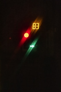 A digital display with the number 83 is illuminated in yellow. A red circle and a green arrow are also visible, suggesting a traffic signal or control panel.