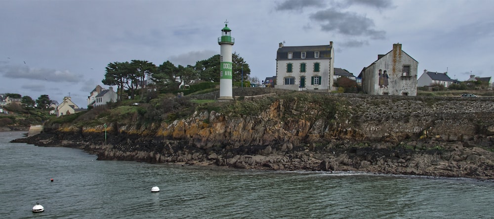 a lighthouse on top of a cliff next to a body of water