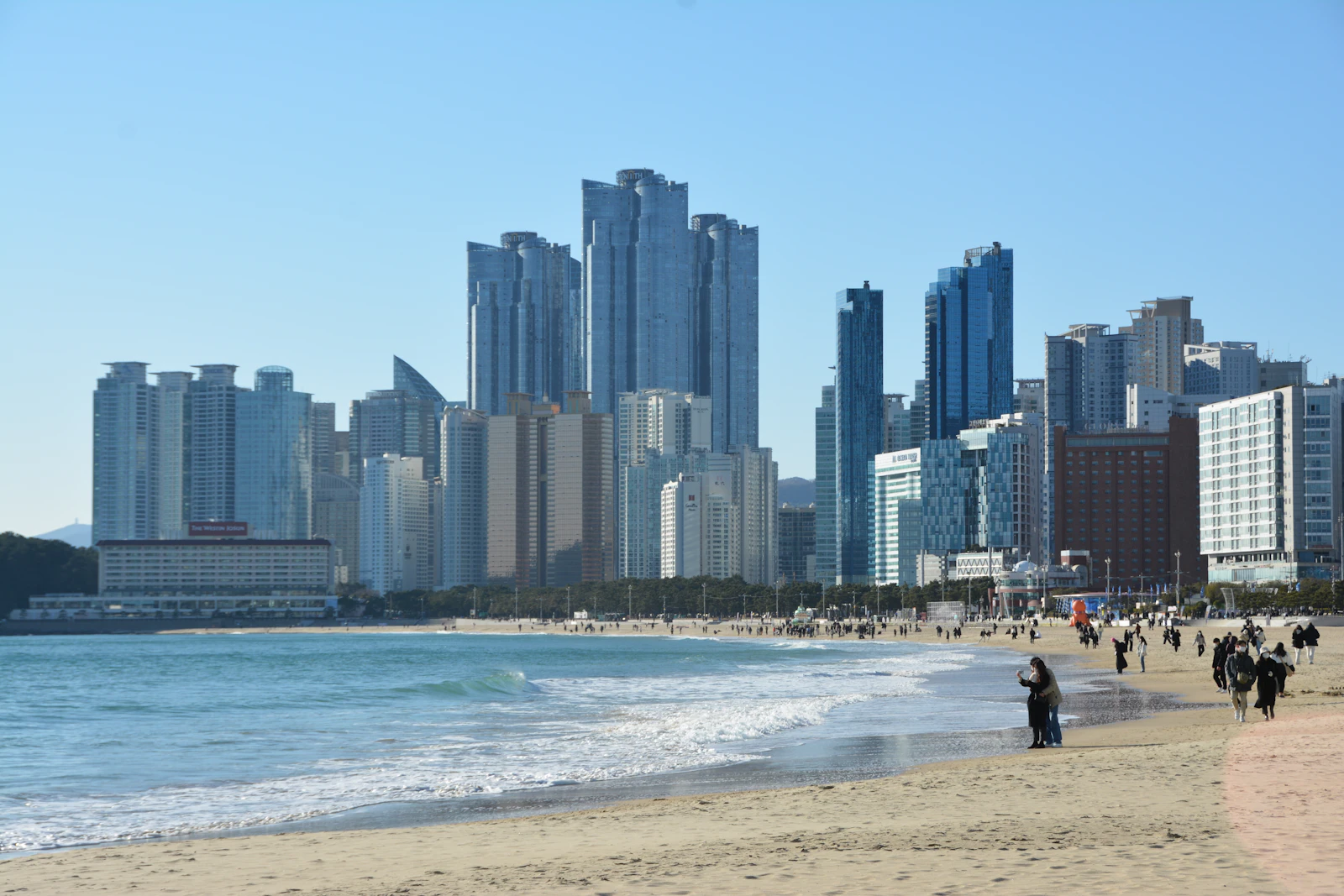 People walking along Haeundae Beach in Busan