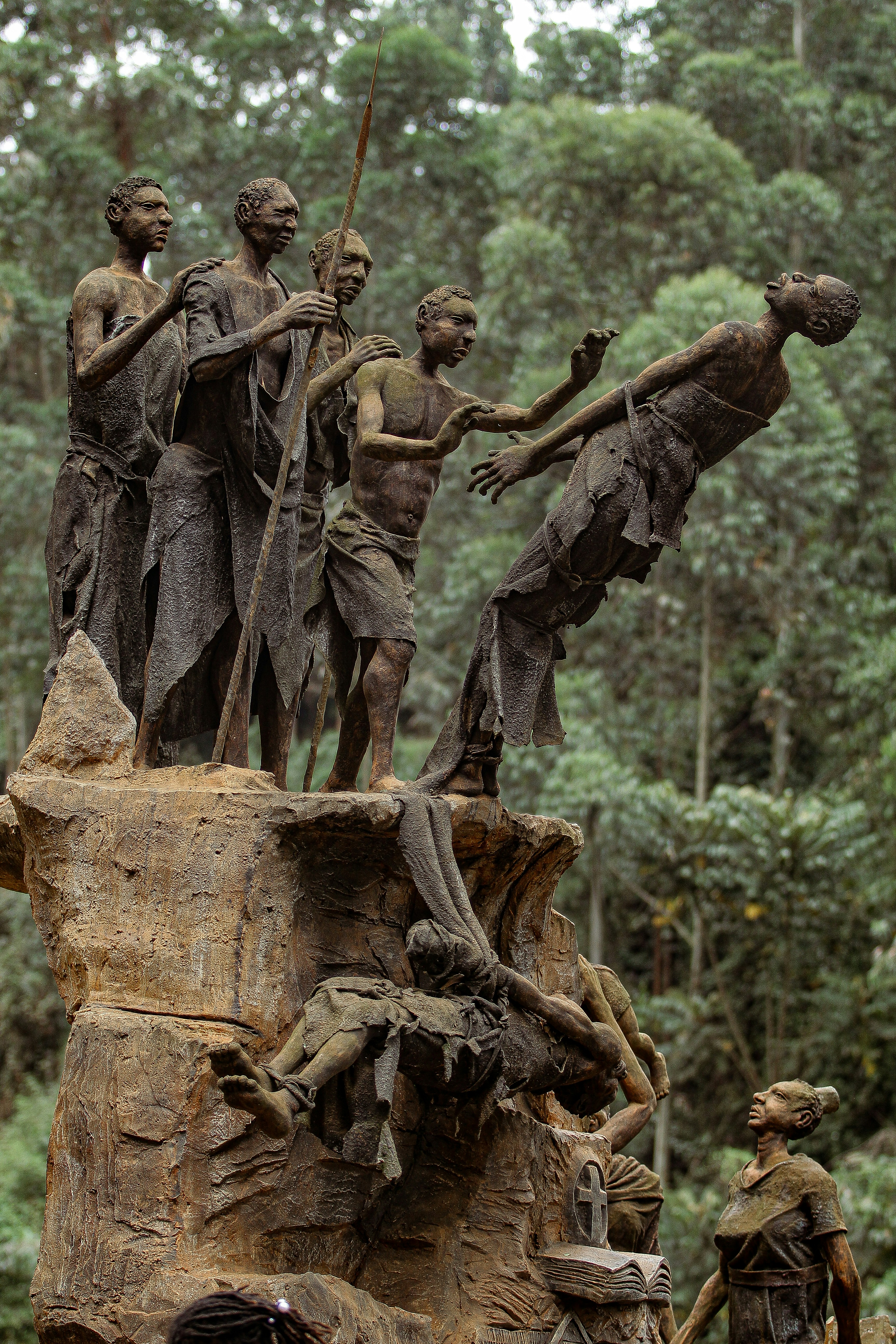 a statue of a group of people standing on top of a tree stump