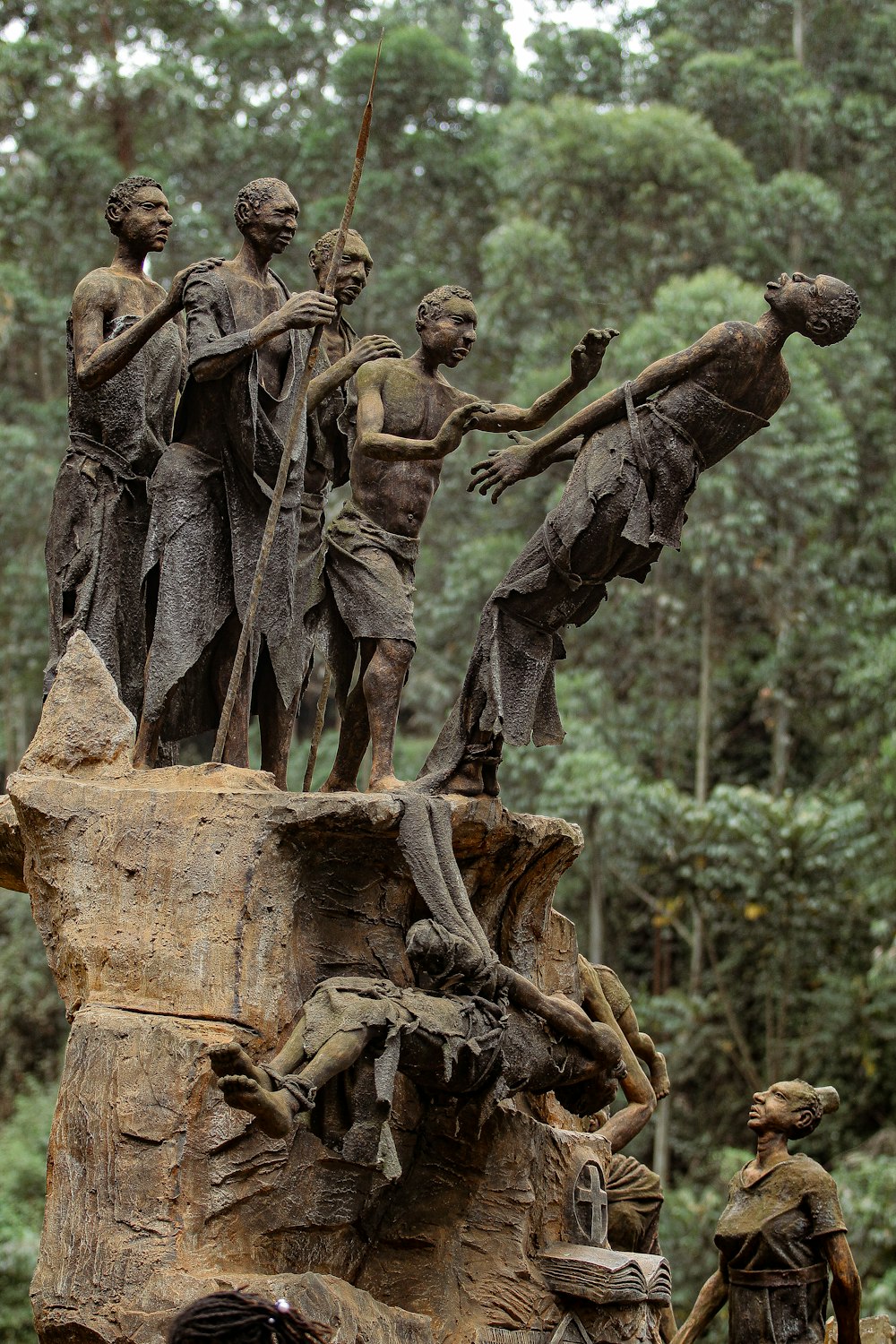 a statue of a group of people standing on top of a tree stump