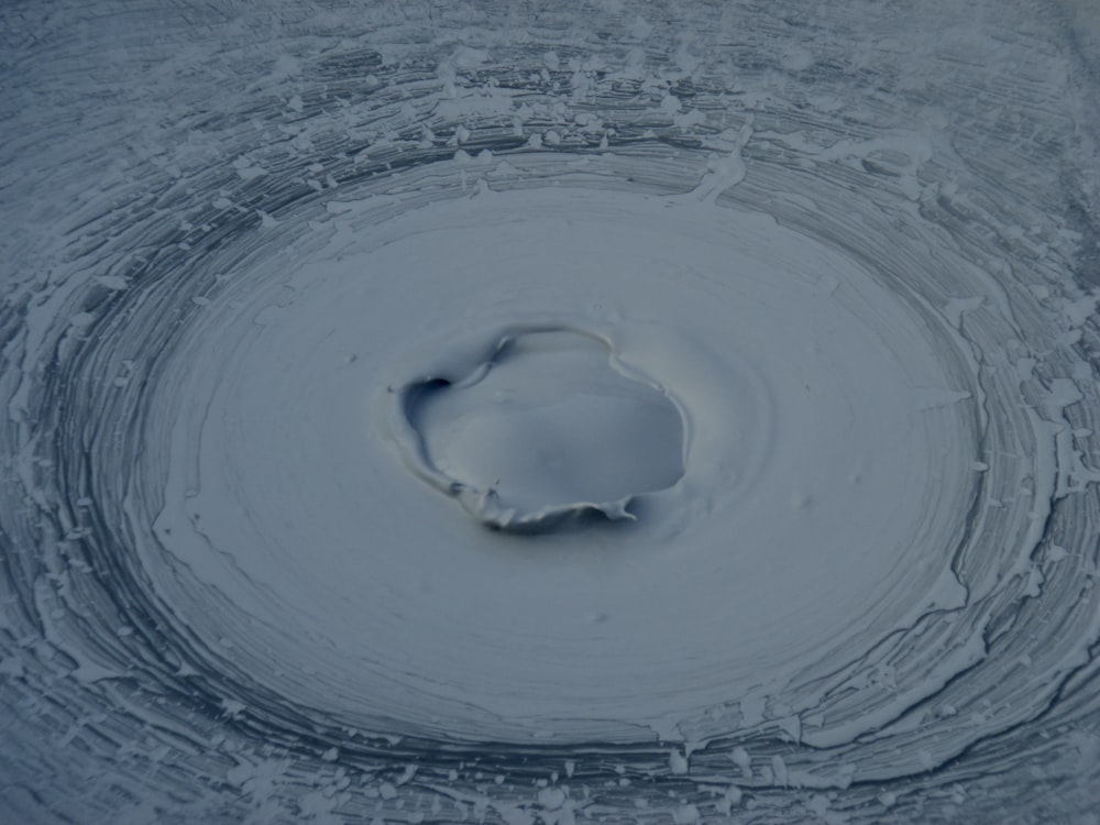 a circular hole in the middle of a snow covered ground