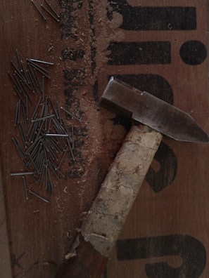 A collection of various roofing nails displayed on a wooden surface.