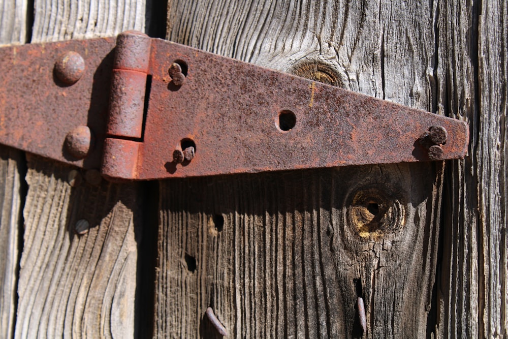 a close up of a metal hook on a wooden fence